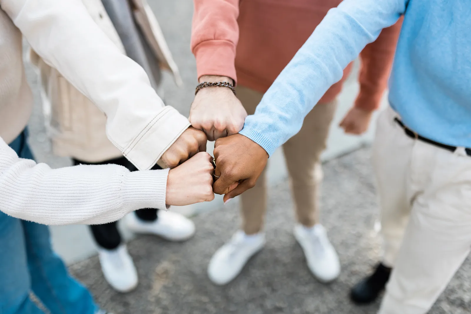 The hands of four people coming together in a fist bump
