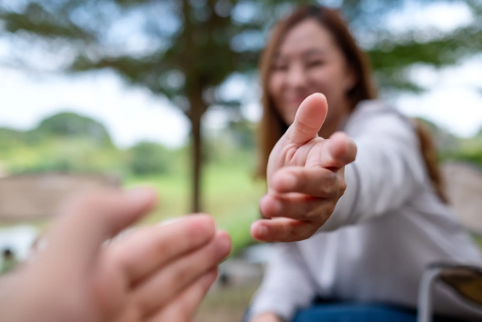 A woman reaches out to help another person move forward